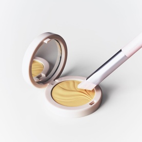 Kylie Cosmetics brush with open compact pressed powder in golden yellow shade, pink rose gold packaging, neutral background