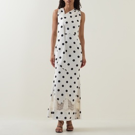 Model wearing Lavish Alice black and white polka dot maxi dress with lace hem detail, styled with black strappy heeled sandals.