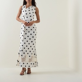 Model wearing Lavish Alice Black/White polka dot maxi dress with lace hem detail, styled with black strappy sandals