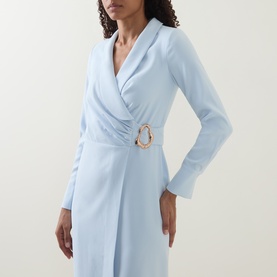 Model wearing Lavish Alice blue wrap dress with long sleeves, V-neckline and gold buckle belt detail at waist.