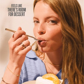 Sol De Janeiro Leite Nectar Perfume Mist lifestyle shot featuring a woman enjoying dessert, evoking the fragrance's sweet, indulgent scent