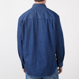 Model wearing A.P.C. washed indigo denim casual shirt, back view, relaxed fit with long sleeves and chest yoke detail