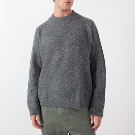 Model wearing A.P.C. heathered anthracite crew neck knit in wool-alpaca blend, styled with khaki trousers