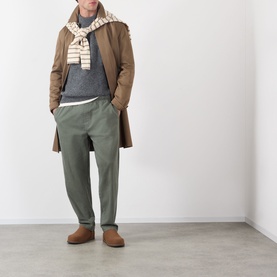 Model wearing A.P.C. Heathered Anthracite crew neck knit, styled with brown overcoat, striped scarf, olive trousers and tan suede loafers.