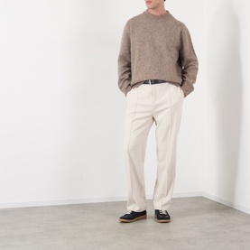 Model wearing A.P.C. taupe alpaca-wool crew neck jumper, styled with cream tailored trousers and black loafers.