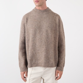 Model wearing A.P.C. taupe crew neck knit jumper in wool-alpaca blend, styled with cream trousers