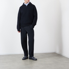 Model wearing A.P.C. dark navy wool half-zip knit, styled with light blue shirt and black trousers and loafers.