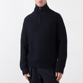 Model wearing A.P.C. dark navy ribbed wool knit half-zip jumper with high neck, styled with black trousers.