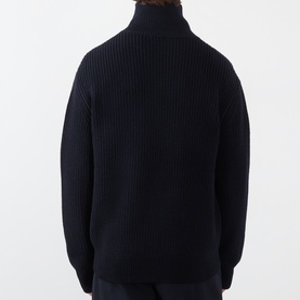 Model wearing A.P.C. dark navy ribbed virgin wool roll-neck jumper, shown from the back with relaxed oversized fit.