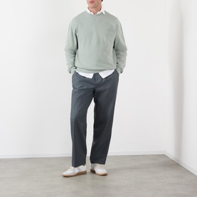 Model wearing A.P.C. Fernando Logo Sweatshirt in gray green with dark charcoal trousers and white trainers.