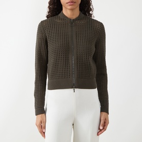 Model wearing Akris Punto olive cotton cardigan with open-knit waffle texture, zip front, and crew neck, styled with white trousers