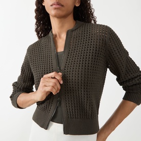 Model wearing Akris Punto olive open-stitch cotton cardigan with zip front, styled over a grey vest top.