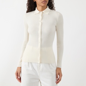 Model wearing Akris Punto cream ribbed wool cardigan with collar and button-front fastening, styled with white trousers