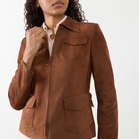 Model wearing Akris Punto hazel suede leather jacket with zip front, flap pockets, and ring pull detail, styled with cream top.