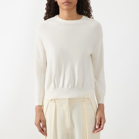 Model wearing Akris Punto cream wool knit jumper with crew neck and ribbed hem, styled with cream wide-leg trousers