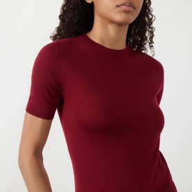 Model wearing Akris Punto pomegranate wool knit top with crew neck and short sleeves, fitted silhouette.