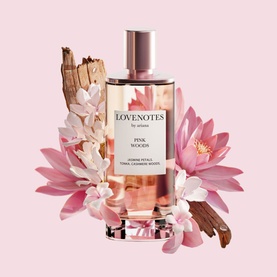 Ariana Grande Lovenotes Pink Woods EDP in glass bottle with rose gold cap, styled with pink florals and wood botanicals on pink background