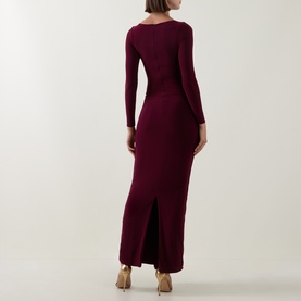 Model wearing Club London burgundy long-sleeve maxi dress, back view, featuring a rear split, styled with nude heeled mules.
