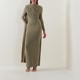 Model wearing khaki green long-sleeve draped cowl neck maxi dress with side split, styled with strappy heeled sandals