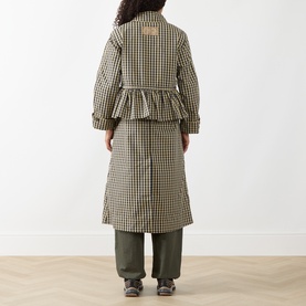 Model wearing Damson Madder Navy Gingham coat with ruffle hem detail, styled with khaki wide-leg trousers. Back view.