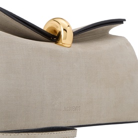 Jacquemus greige and black calf leather clutch with gold-tone circular clasp closure, close-up detail view