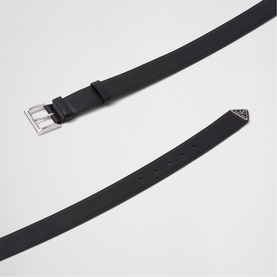 Prada Accessories black leather belt with silver-tone buckle and triangular logo tip detail, shown flat against white background.