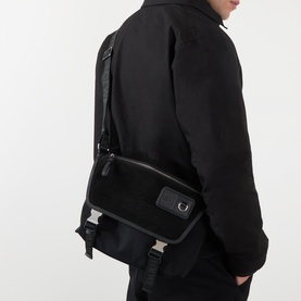Model carrying Loewe Flex Messenger Crossbody Bag in black canvas and suede with silver-tone hardware, worn across body over black jacket