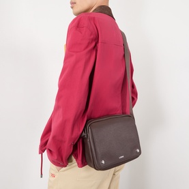Model carrying Loewe Pebble Logo Messenger Bag in chocolate grained leather, silver-tone hardware, adjustable strap, styled with red top and beige