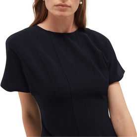 Model wearing Hobbs blue short-sleeve dress with vertical seam detail, round neckline, styled with pearl stud earrings