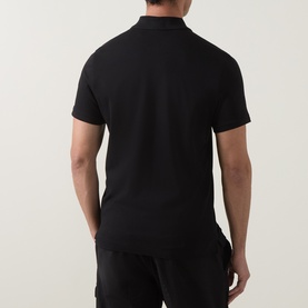 Model wearing Moose Knuckles black cotton polo shirt, shown from the back, with matching black trousers.