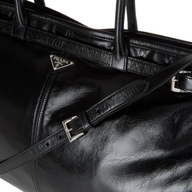Prada black leather tote bag with silver buckle strap detail and triangular logo plaque, close-up view