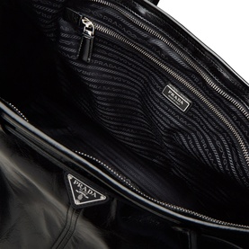 Prada black nylon and leather bag interior, showing quilted lining, multiple zip pockets and silver-tone hardware detail