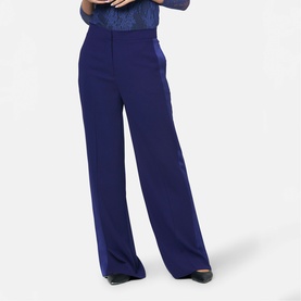 Model wearing Helen McAlinden ink blue wide-leg trousers with high waist, styled with a blue patterned top and black heels.