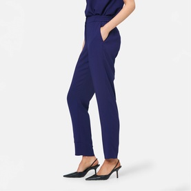 Model wearing Helen McAlinden ink blue slim-leg trousers with side pockets, styled with black slingback heels.