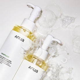 Anua Heartleaf Cleansing Oil duo with pump dispensers, displayed on white surface with water bubbles and glass spheres