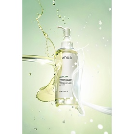 Anua pump-bottle cleanser surrounded by a dynamic water and oil splash against a light green background