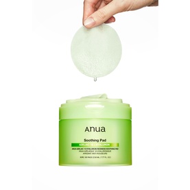 Anua Soothing Pad toner pads in green jar, one pad held above showing dripping liquid texture