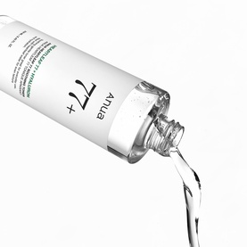 Anua 77+ toner in white pump bottle, shown pouring a stream of clear liquid formula