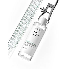 Anua 77+ toner in clear bottle with dropper applicator and spiral glass tool on white background