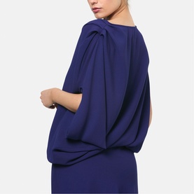 Model wearing Helen McAlinden ink blue dress with draped cape-style back detail and split sleeves, shown from behind.