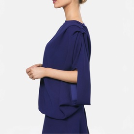 Model wearing Helen McAlinden ink blue top with draped shoulder detail and cropped sleeves, side profile view