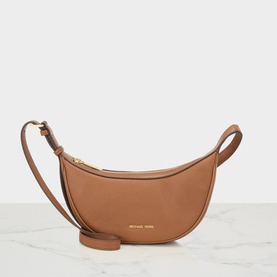 MMK luggage tan leather crossbody bag with gold-tone branding, curved base, zip top, and adjustable shoulder strap