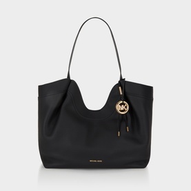 MMK black leather tote bag with gold-tone MK logo charm, tassel detail, and single shoulder strap