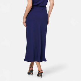 Model wearing Helen McAlinden ink blue midi skirt, shown from behind, styled with black heeled sandals.
