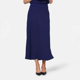 Model wearing Helen McAlinden ink blue midi skirt with flared hem, styled with black heels