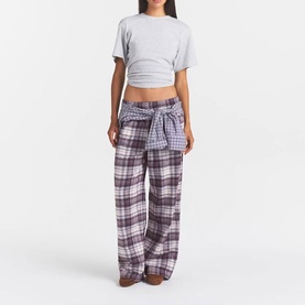 Model wearing Skims PJ Pants in Iris Mica Plaid, wide-leg flannel check with tie waist, styled with a grey crop top