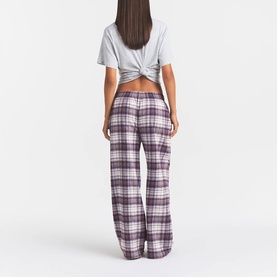 Model wearing Skims PJ Pants in Iris Mica Plaid check, wide-leg fit, styled with a grey twisted crop top. Rear view.