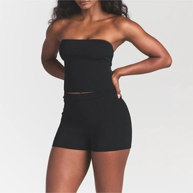 Model wearing Skims black bandeau top, styled with matching black shorts