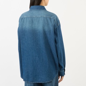 Model wearing The Frankie Shop shirt in Raw Wash denim, back view, oversized fit with long sleeves and curved hem