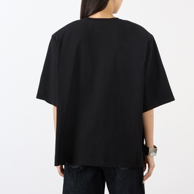 Model wearing The Frankie Shop black oversized cotton T-shirt, rear view, styled with dark jeans.